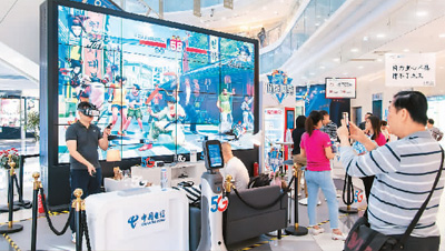 中国电信为消费者提供5G应用场景。上海市民正在商场内体验5G手机的高速网络和5G+8K云VR以及云游戏。(王冈/人民图片)